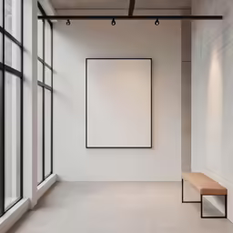 an empty room with a bench and big square poster