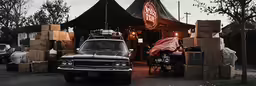 an old truck and car stacked in front of a building