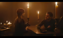 a man with a candle sitting next to a woman at a bar
