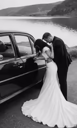 a bride and groom kiss by the side of the car