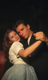 a man and woman dance together on the stage