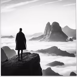 man with jacket on standing in the foggy mountains