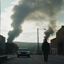 the smoke billows out of the exhaust from a man walking across a street