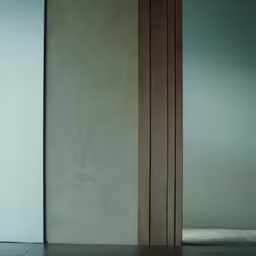 a vase on the floor by two tall doors