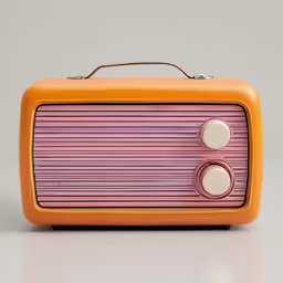 the yellow and pink colored old fashioned radio is on the ground