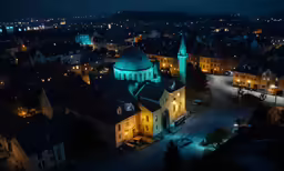 aerial view of old town at night with tall clock tower