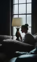 a woman sits on a couch and looks out the window
