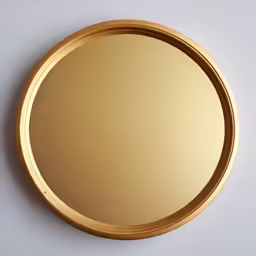 a gold circular mirror on a gray background