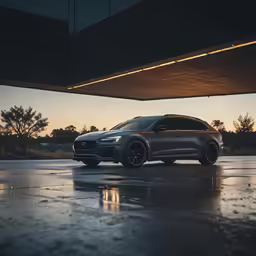 a car driving on a wet road by the side of a building