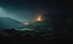 a long exposure of lights shine over a mountain at night