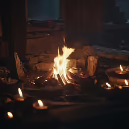 a fire with many lit candles sitting in a wooden room