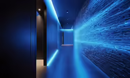 an empty hallway in a dark room with blue lights