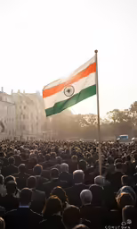 a large group of people standing in a city square with india flag
