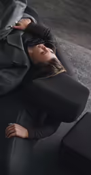 a woman laying on the floor in a black jumpsuit