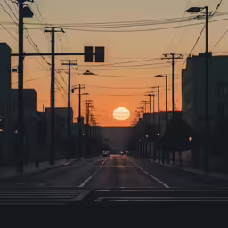 the sun setting at dusk on the side of a city street