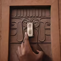 someone holding a door knob in a square shaped entry