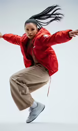 an athlete does a jump with her hair in the air
