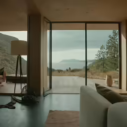 a view from a modern house with open doors and a fireplace