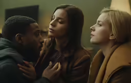 three people looking at each other in the same room