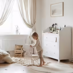 a little boy is playing with his chair in the bedroom