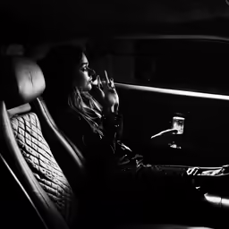 a woman sitting in the backseat of a car talking on a phone