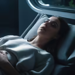 the woman is laying on the train under the blanket
