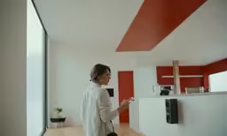 a woman standing at the counter of a kitchen