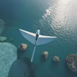 a large airplane is flying over some blue water