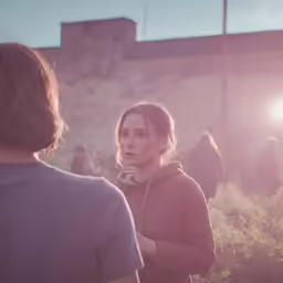 a woman standing next to a man in a field
