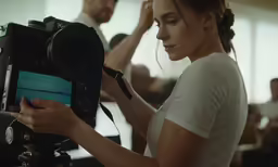 a woman is adjusting the controls on an old fashioned camera