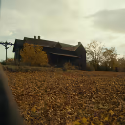 an old house sits in the middle of the autumn foliage
