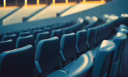 rows of blue seats with orange stripe in auditorium