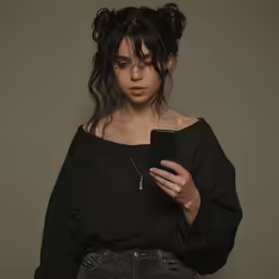 a young woman holding a phone with one hand
