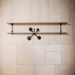 a wall with two shelves and several hooks on it