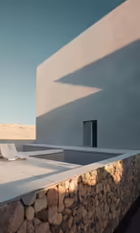 a concrete building has a pool in the back
