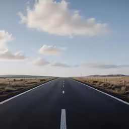 empty highway with blue sky and puffy clouds