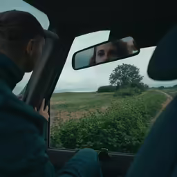 a woman looking out the window of a car