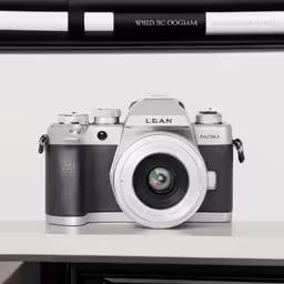 a black camera sitting on top of a wooden shelf