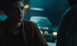 a young man looking away from a car