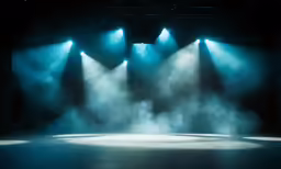 an empty theater with lights and smoke on the floor