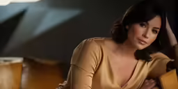 a woman sitting on top of a couch holding her arm in the air