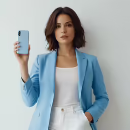 a woman poses for the camera in her white pants, blue jacket, and tank top
