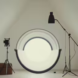 a studio with the light lighting a photo camera and another tripod
