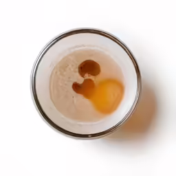 the top half of a glass that has something in it
