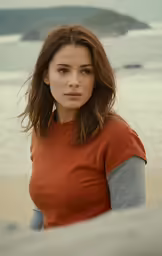 a young woman stands on the beach in front of the ocean