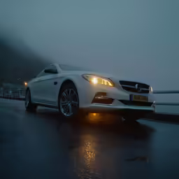 a white car parked on the road in the rain