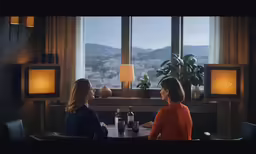 two ladies sitting at the table with wine and drinks