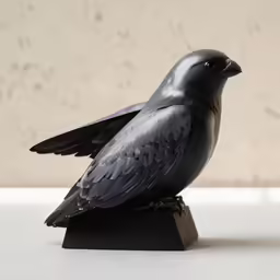 a small statue of a black bird is sitting