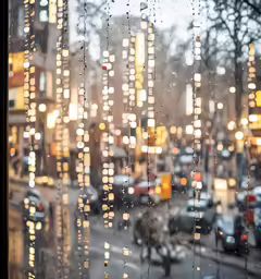 many cars driving down the street during a rain storm