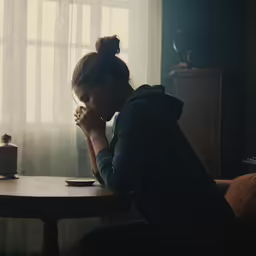 the woman is sitting in a chair and she is reading